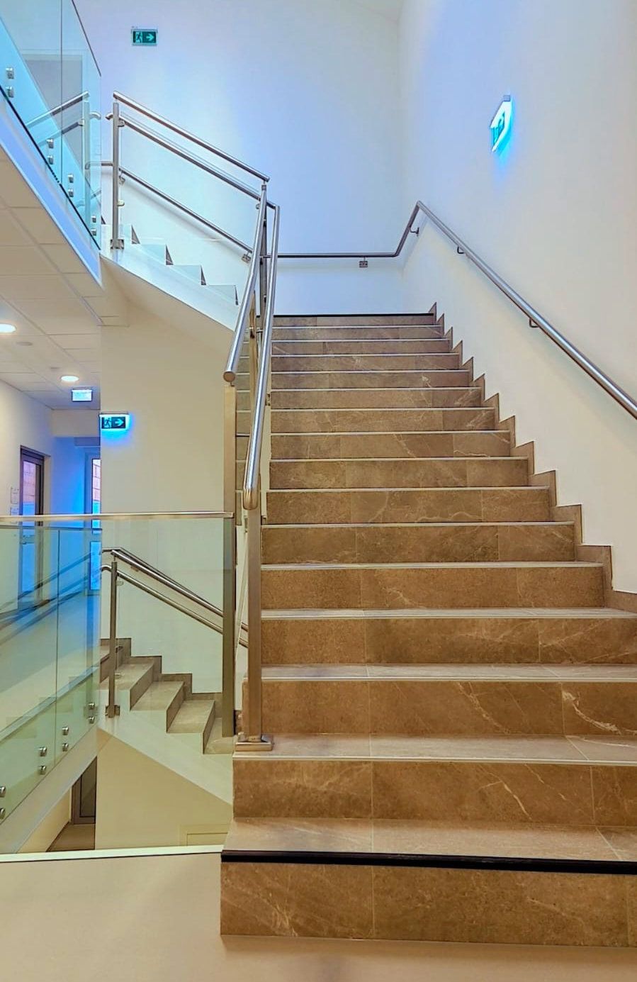 Edelstahl-Treppengeländer mit Glas Modernes Edelstahl-Treppengeländer mit Glasfüllung in einem Bürogebäude